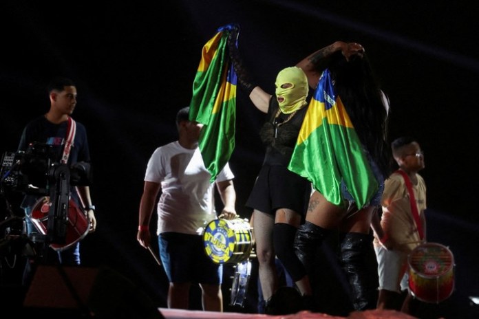 Madonna sostiene una bandera brasileña durante el ensayo con sus bailarines. Foto: Reuters