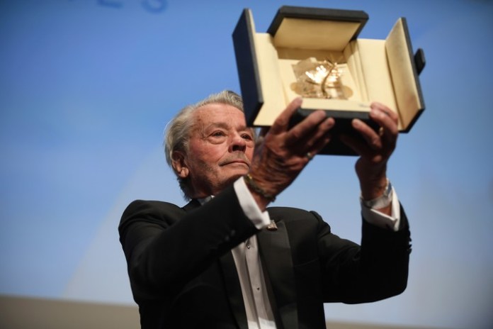 Delon muestra al público su Palma de Oro honoraria el 19 de mayo de 2019. La recibió a pesar de la oposición de asociaciones feministas. Foto AP