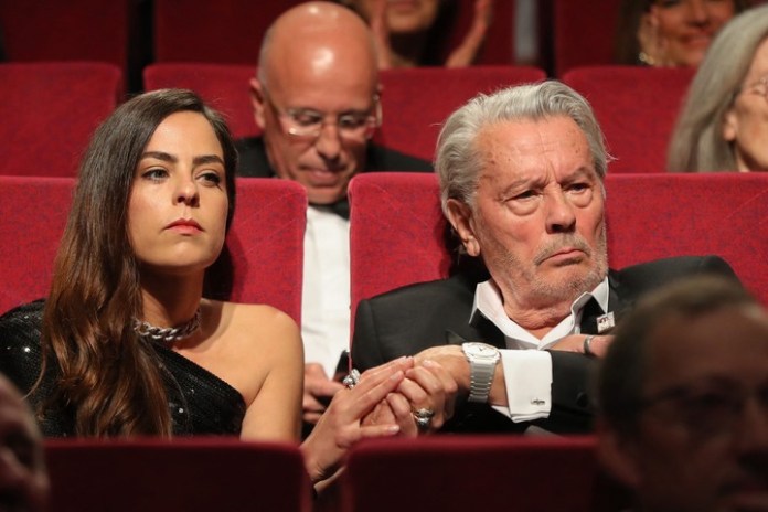Delon toma la mano de su hija, la actriz francesa Anouchka Delon, antes de recibir la Palma de Oro honorífica en Cannes. Foto AFP